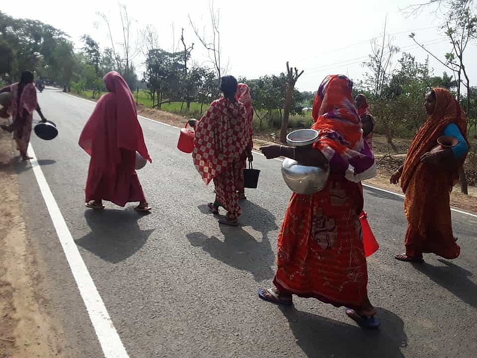 রাজশাহীর তানোর উপজেলায় সুপেয় পানির সংকটের কারণে গভীর নলকূপ থেকে পানি আনতে যাচ্ছেন কয়েকজন নারী। সম্পতি মুন্ডুমালা পৌর এলাকার 
মাহালেপাড়ায়
