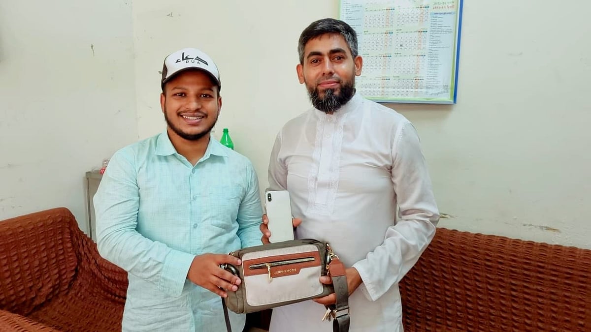 বাসে পাওয়া ব্যাগটি আসল মালিক আনোয়ার হোসনকে ফেরত দেন হাবিবুর রহমান (বাঁয়ে)