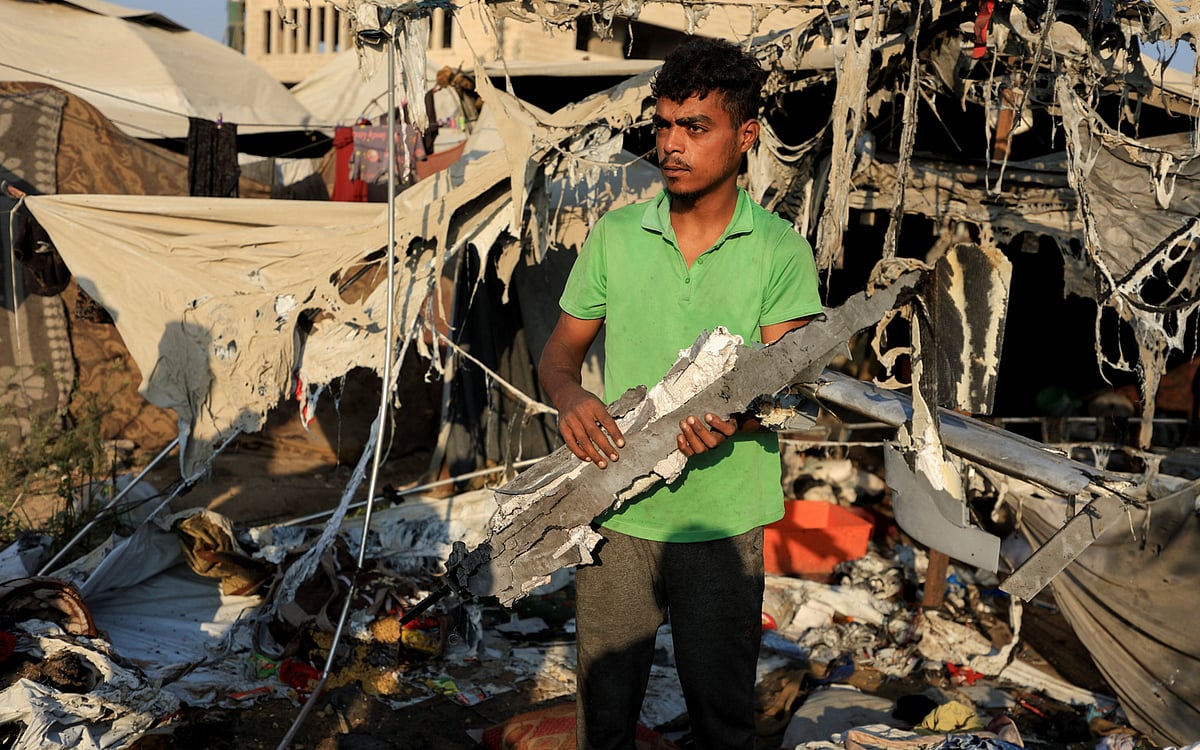 গাজা নগরীতে ইসরায়েলি হামলার পর একটি ধ্বংসাবশেষ হাতে এক ফিলিস্তিনি যুবক, ৫ আগস্ট ২০২৫