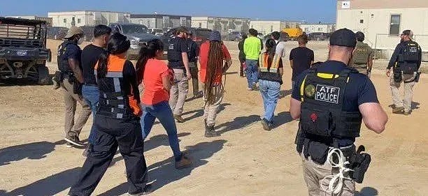 জর্জিয়ায় হুন্দাইয়ের কারখানা থেকে আটক ব্যক্তিদের নিয়ে যাচ্ছে পুলিশ