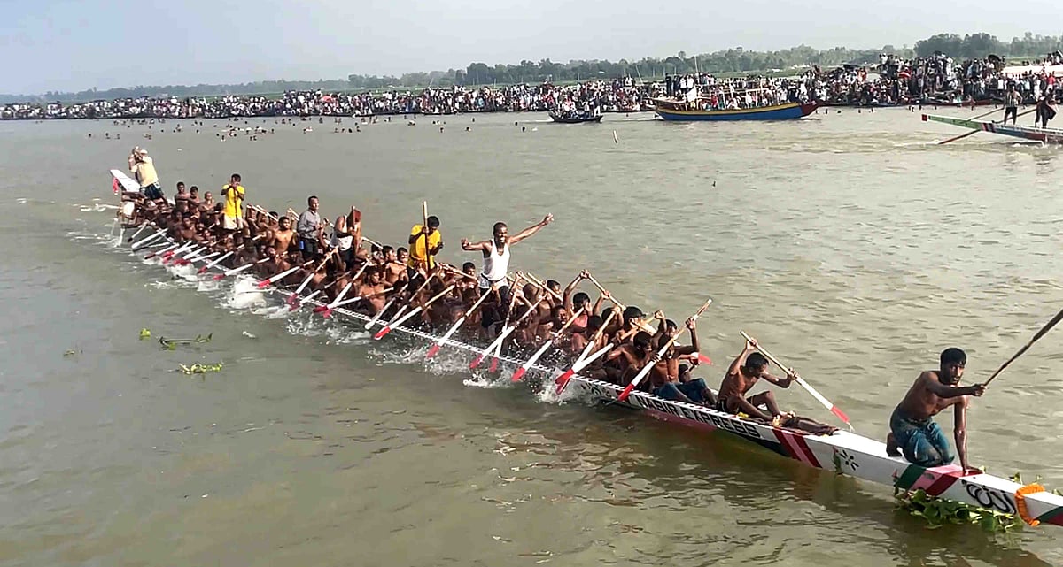 রঙিন পতাকা, ঢাকের বাদ্য আর নান্দনিক সাজে প্রতিটি নৌকাকে আলাদা করা যাচ্ছিল