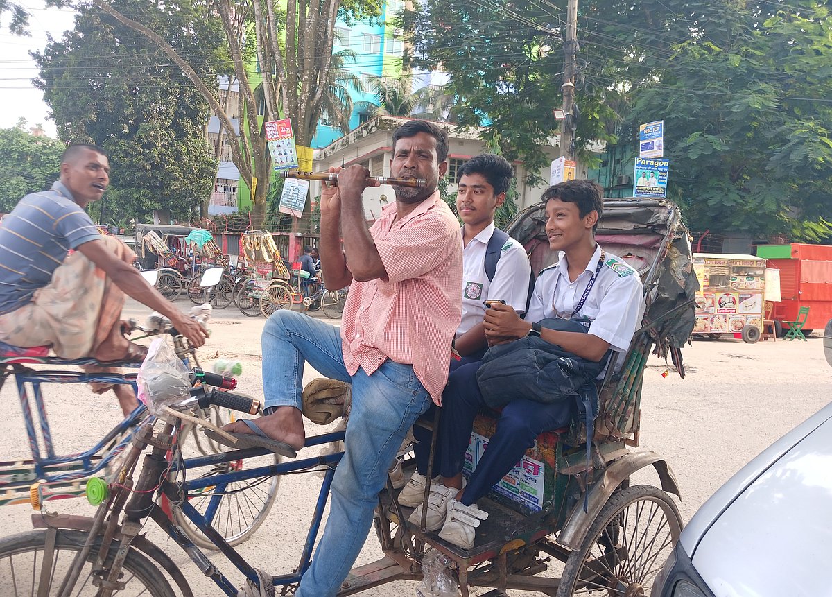 বগুড়া শহরে যানজটে রিকশায় বসে বাঁশি বাজাচ্ছেন চালক শফিকুল ইসলাম। গত রোববার বগুড়া শহরের জেলখানা মোড় এলাকায়