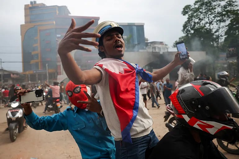 নেপালের কাঠমান্ডুতে সরকারবিরোধী বিক্ষোভ ও কারফিউ চলাকালে পার্লামেন্ট ভবনের বাইরে মুঠোফোনে ছবি তুলছেন আন্দোলনকারীরা। ৯ সেপ্টেম্বর ২০২৫, নেপাল