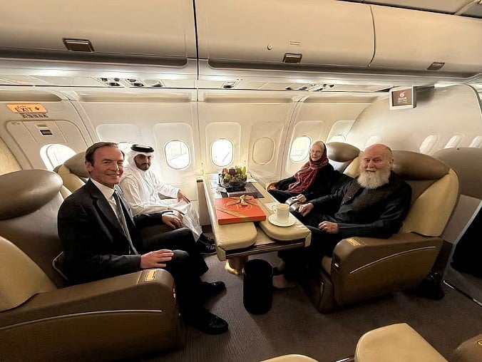 কাতারি ও ব্রিটিশ কূটনীতিকদের সঙ্গে একটি উড়োজাহাজে বসে আছেন পিটার এবং বারবি রেনল্ডস। ১৯ সেপ্টেম্বর, ২০২৫