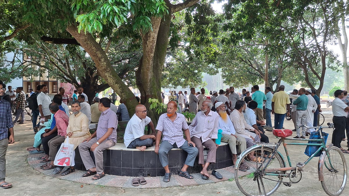 রাজশাহী বিশ্ববিদ্যালয়ের প্রশাসন ভবনের পশ্চিম পাশে বসে আছেন শিক্ষক-কর্মকর্তা-কর্মচারীরা। আজ রোববার সকাল সাড়ে নয়টার দিকে