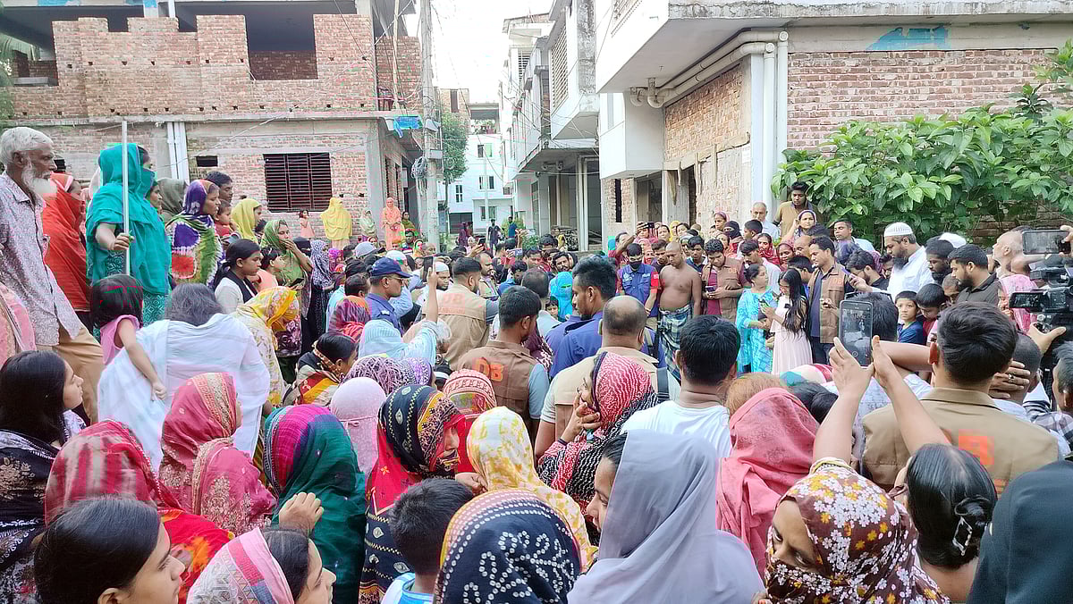 মানিকগঞ্জে তিনজনের লাশ উদ্ধারের খবরে বাসাটির সামনে উৎসুক লোকজনের ভিড়। মঙ্গলবার দুপুরে জেলা শহরের পশ্চিম বান্দুটিয়া এলাকায়