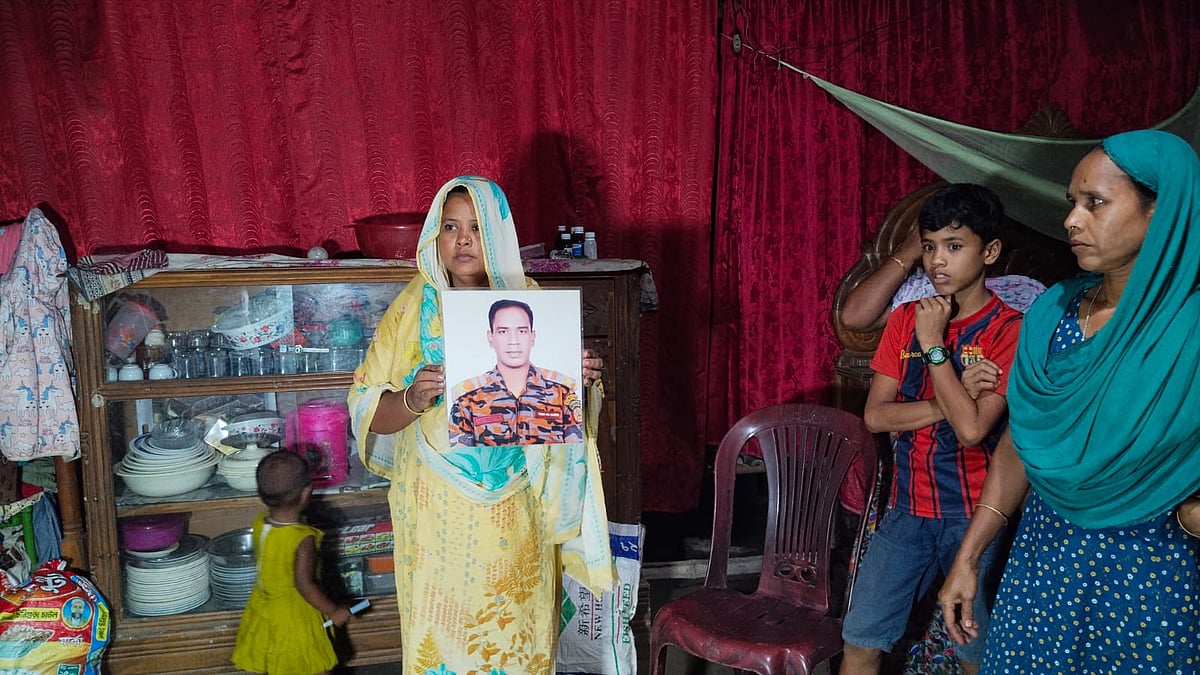 ফায়ার সার্ভিস কর্মী শামীম আহমেদের মৃত্যুর খবরে তাঁর গ্রামের বাড়ি নেত্রকোনার কেন্দুয়া উপজেলার মাসকা ইউনিয়নের পিজাহাতিতে চলছে শোকের মাতম। ছবি হাতে নিয়ে কাঁদছিলেন তাঁর বড় ভাই সবুজ মিয়ার স্ত্রী লাকি আক্তার