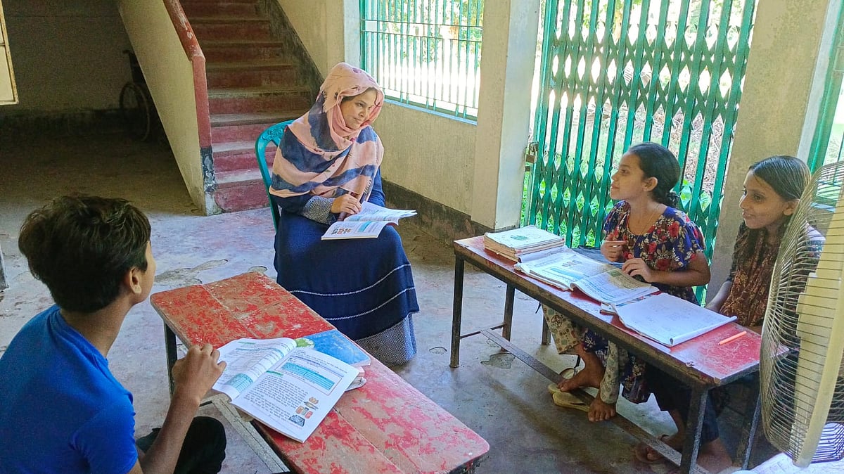 তিন শিক্ষার্থী নিয়ে পাঠদান করছেন ময়মনসিংহের গফরগাঁওয়ের ভাতুরি সরকারি প্রাথমিক বিদ্যালয়ের শিক্ষক আবিদা সুলতানা। বিদ্যালয় ভবনটি পরিত্যক্ত হওয়ায় পাশের বাড়ির বারান্দায় চলছে পাঠদান। ছবিটি ২৪ সেপ্টেম্বর দুপুরে তোলা