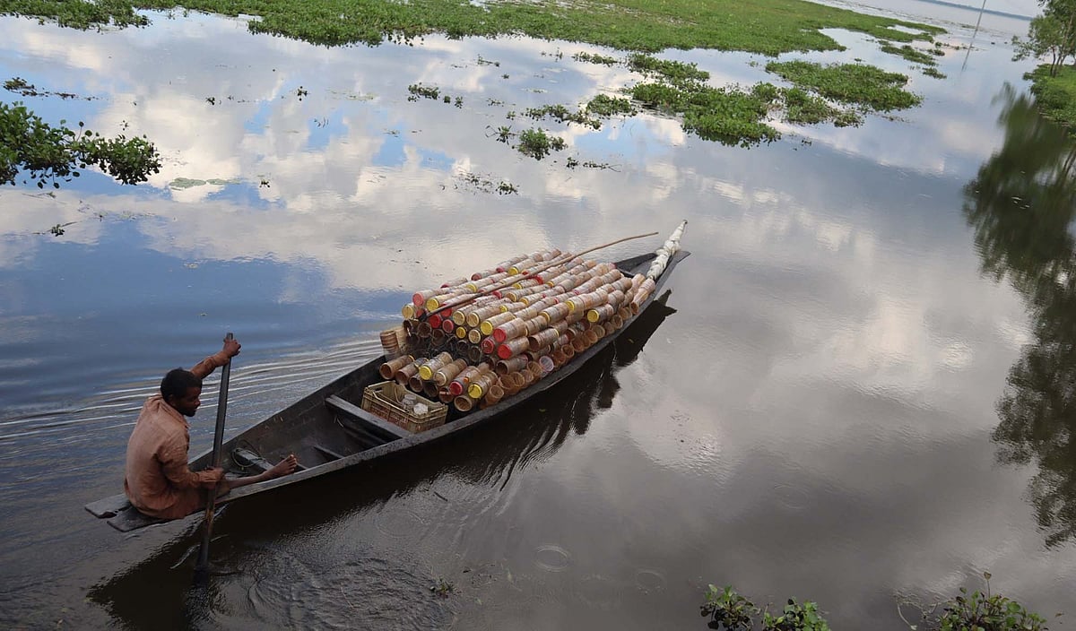 চিংড়ি মাছ ধরতে নৌকায় ‘কিরণমালা’ ফাঁদ নিয়ে হাওরের দিকে ভেসে যাচ্ছেন এক জেলে। গত শুক্রবার বিকেলে মৌলভীবাজারের কাউয়াদীঘি হাওরপারের কাদিপুরে