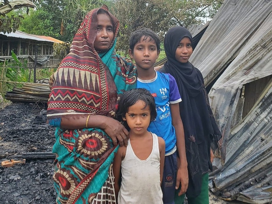 পোড়া ঘরের সামনে সন্তানসহ রহিমা বেগম। আজ দুপুরে লোহাগাড়ার চুনতি রোসাইঙ্গা ঘোনা গ্রামে
