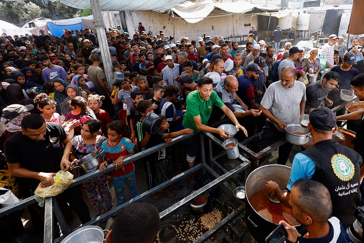 একমুঠো খাবারের আশায় অসহায় ফিলিস্তিনিদের ভিড়। তাঁদের মধ্যে রয়েছে শিশুরাও। ইসরায়েলের অবরোধের মুখে দিনের পর দিন অনাহার–অর্ধাহারে দিন কাটছে তাঁদের। গতকাল গাজার মধ্যাঞ্চলের নুসেইরাত এলাকার একটি দাতব্য সংস্থার ত্রাণ বিতরণকেন্দ্রে