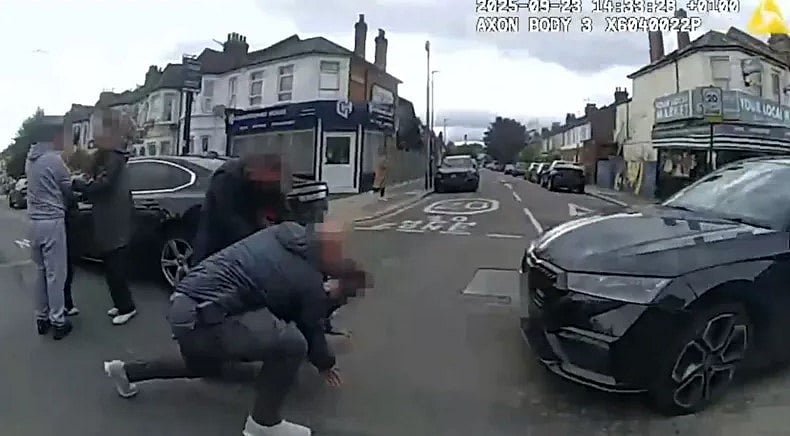 পুলিশের বডিক্যামে ধারণ করা ফুটেজে দেখা যায়, সাধারণ পোশাকধারী এক পুলিশ কর্মকর্তা এক ব্যক্তিকে রাস্তার মাঝখানে ফেলে দিয়ে আটকানোর চেষ্টা করছেন