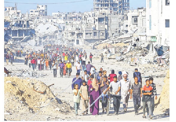 যুদ্ধবিরতির পর ইসরায়েলি হামলায় ধ্বংসস্তূপের পাশ দিয়ে নিজেদের এলাকায় ফিরছেন ফিলিস্তিনিরা। গতকাল গাজা উপত্যকার খান ইউনিসে