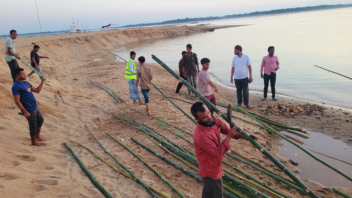 সুনামগঞ্জের যাদুকাটা নদীর তীর কেটে বালু লুট বন্ধে বাঁশের বেড়া দেওয়া হচ্ছে। গতকাল রোববার বিকেলে নদীর লাউড়েরগড় এলাকায়