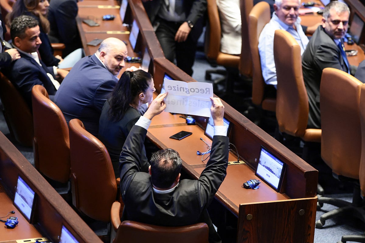 ইসরায়েলের পার্লামেন্টে ট্রাম্প ভাষণ দেওয়ার সময় এক এমপি ‘ফিলিস্তিনকে স্বীকৃতি দিন’ লেখা সংবলিত একটি কাগজ উঁচিয়ে ধরেছিলেন। ১৩ অক্টোবর ২০২৫, জেরুজালেম