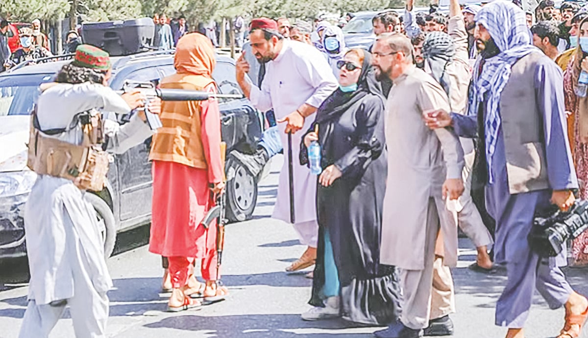 আফগানিস্তানের রাজধানী কাবুলে নারী বিক্ষোভকারীর দিকে বন্দুক তাক করে ধরেন এক তালেবান সদস্য