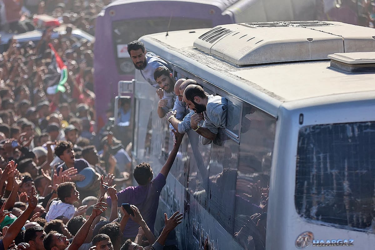 ইসরায়েলের কারাগার থেকে মুক্ত ফিলিস্তিনিদের বাসে করে নেওয়া হচ্ছে। এ সময় হাজার হাজার ফিলিস্তিনি তাঁদের স্বাগত জানান। ১৩ অক্টোবর ২০২৫, খান ইউনিসে নাসের হাসপাতালের বাইরে