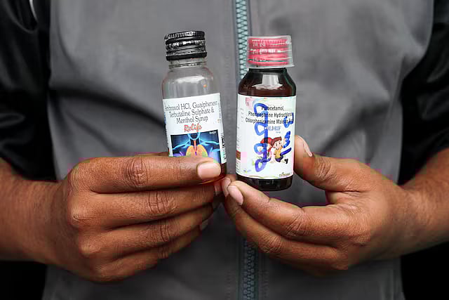 কোল্ডরিফ ও রিলাইফ কফ সিরাপের বোতল হাতে এক ব্যক্তি