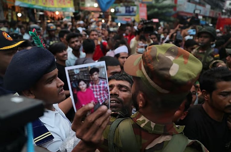 ছবি নিয়ে নিখোঁজ স্বজনের খোঁজ। মঙ্গলবার ঢাকার মিরপুর রূপনগরের শিয়ালবাড়িতে