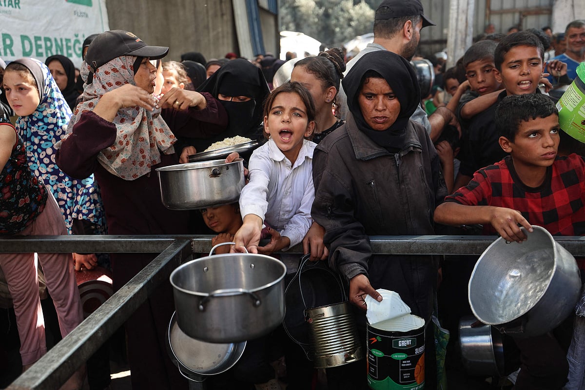 খাবারের আশায় ফিলিস্তিনিদের ভিড়। বুধবার গাজার নুসেইরাত শরণার্থীশিবিরে একটি ত্রাণকেন্দ্রে