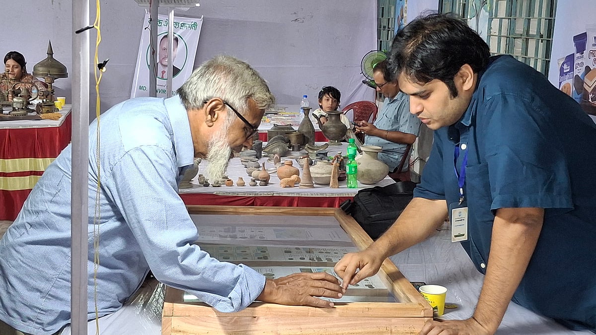 প্রদর্শনীতে প্রাচীন মুদ্রা দেখছেন এক দর্শনার্থী। শনিবার বিকেলে রাজশাহী নগরের শালবাগান এলাকায়