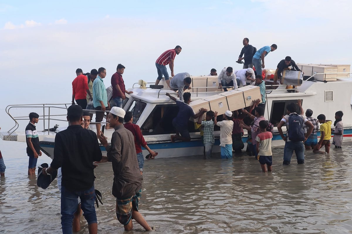 সন্দ্বীপের কুমিরা ঘাটে স্পিডবোট থেকে নামানো হচ্ছে সাত প্রবাসীর লাশ। আজ সকাল আটটায়