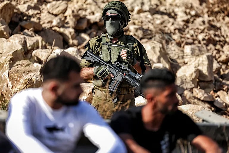 অধিকৃত পশ্চিম তীরের রামাল্লার পশ্চিমে ফিলিস্তিনি গ্রাম বেইত উর আল–ফৌকার কাছে ইসরায়েলি বসতি স্থাপনকারীদের জন্য নির্মাণাধীন নতুন সড়কের স্থানে বিক্ষোভ দেখাতে সমবেত হন ফিলিস্তিনিরা। এ সময় তাঁদের পাহারা দেন ইসরায়েলি সেনারা। ২৯ সেপ্টেম্বর ২০২৫