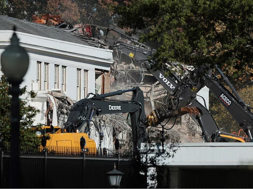 একটি খননযন্ত্র (এক্সকাভেটর) হোয়াইট হাউসের ইস্ট উইং ভাঙার কাজ করছে