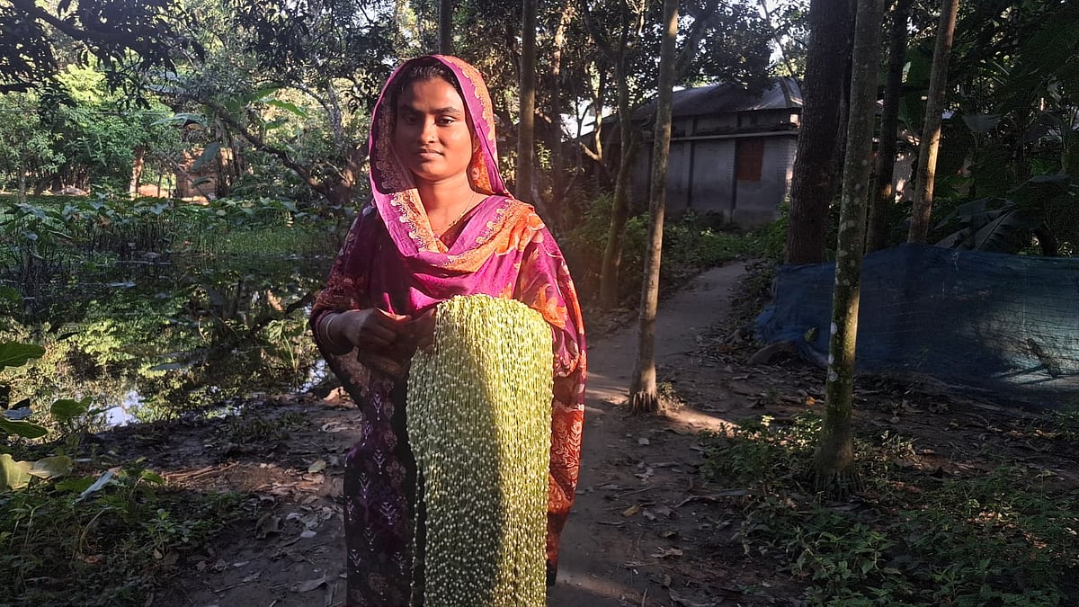 গ্রামের নারী কারিগরদের গাঁথা মালা মহাজনের কাছে জমা দিতে যাচ্ছেন যূথী খাতুন। গত বুধবার বিকেলে নাটোরের লালপুর উপজেলার মনিহারপুর গ্রামে