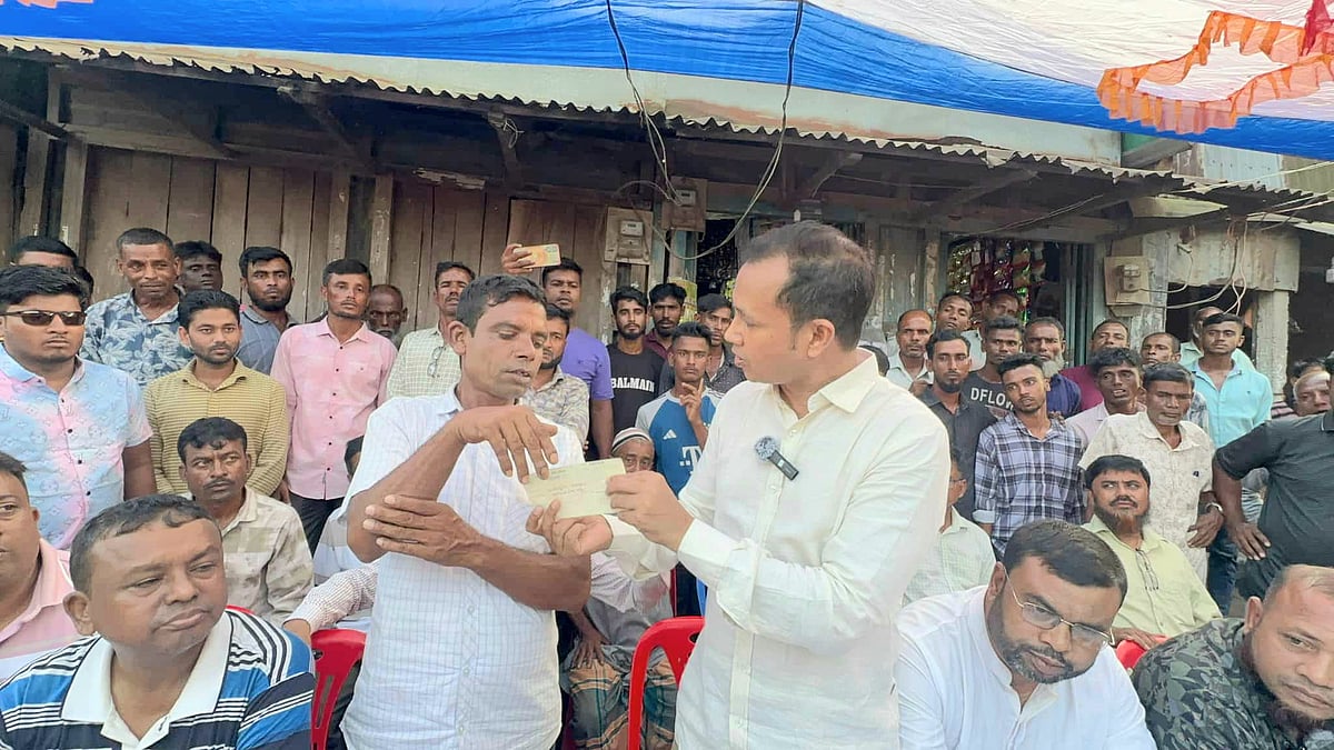 বিএনপির কর্মী নূর কাসেমকে ১০ লাখ টাকার চেক ফেরত দিচ্ছেন দলটির নেতা কামরুজ্জামান কামরুল। রোববার বিকেলে সুনামগঞ্জের তাহিরপুর উপজেলার একতা বাজারে