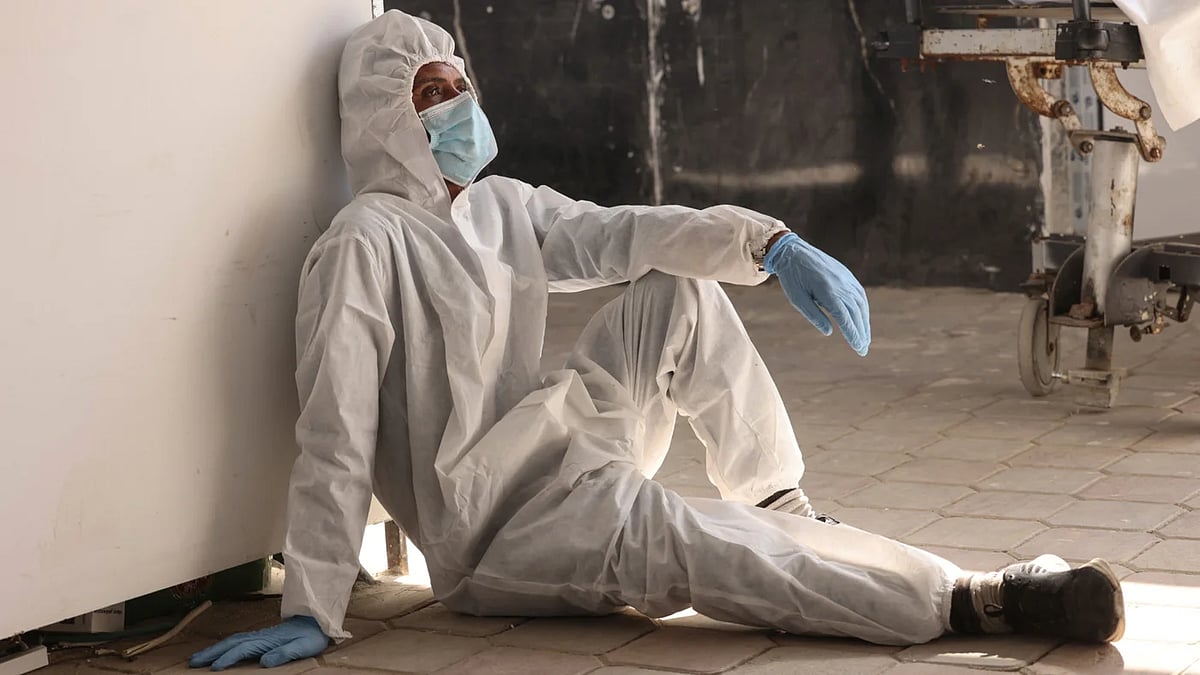 ইসরায়েলের হস্তান্তর করা ৩০ ফিলিস্তিনি বন্দীর দেহাবশেষ বুঝে নেওয়ার পর বিশ্রাম নিচ্ছেন হাসপাতালের এক কর্মী। গাজার নাসের মেডিকেল কমপ্লেক্স; ৩১ অক্টোবর ২০২৫