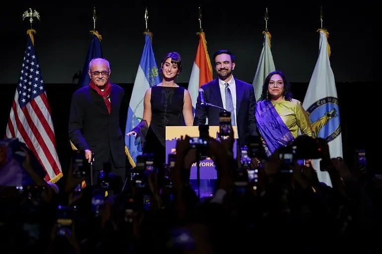 সমর্থকদের উদ্দেশে কথা বলছেন জোহরান মামদানি। পাশে তাঁর বাবা মাহমুদ মামদানি, স্ত্রী রমা দুওয়াজি ও মা মীরা নায়ার (ডানে)। যুক্তরাষ্ট্রের নিউইয়র্কে, ৪ নভেম্বর ২০২৫