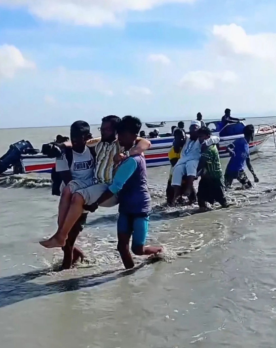 দুজন যাত্রীকে স্পিডবোট থেকে ঘাটে তোলা হচ্ছে। সম্প্রতি সন্দ্বীপের গুপ্তছড়া ঘাট এলাকায়