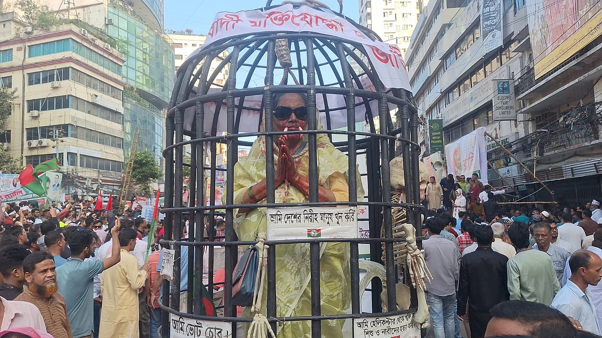 খাঁচার ভেতরে একজন নারী শেখ হাসিনার সাজে দাঁড়িয়ে আছেন। তাঁকে কারাবন্দী হিসেবে দেখানো হয়েছে। ৭ নভেম্বর
