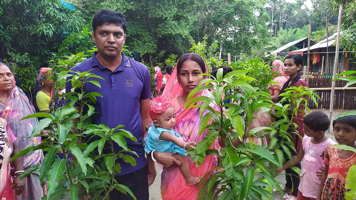 মেয়ে সম্প্রীতি ব্রহ্মকে নিয়ে গ্রামবাসীর মাঝে ফলের চারা বিতরণ করছেন মাধব-সাথী দম্পতি। আজ শনিবার সকালে বাগেরহাটের চিতলমারী উপজেলার সদর ইউনিয়নে কালশিরা গ্রামে