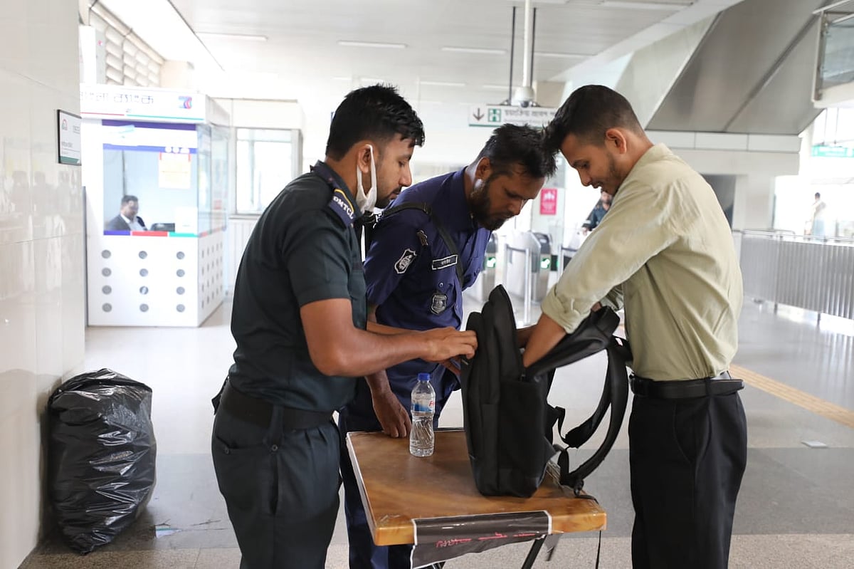 আগারগাঁও মেট্রো স্টেশনে যাত্রীর ব্যাগ তল্লাশি করছেন আইনশৃঙ্খলা রক্ষাকারী বাহিনীর সদস্যরা