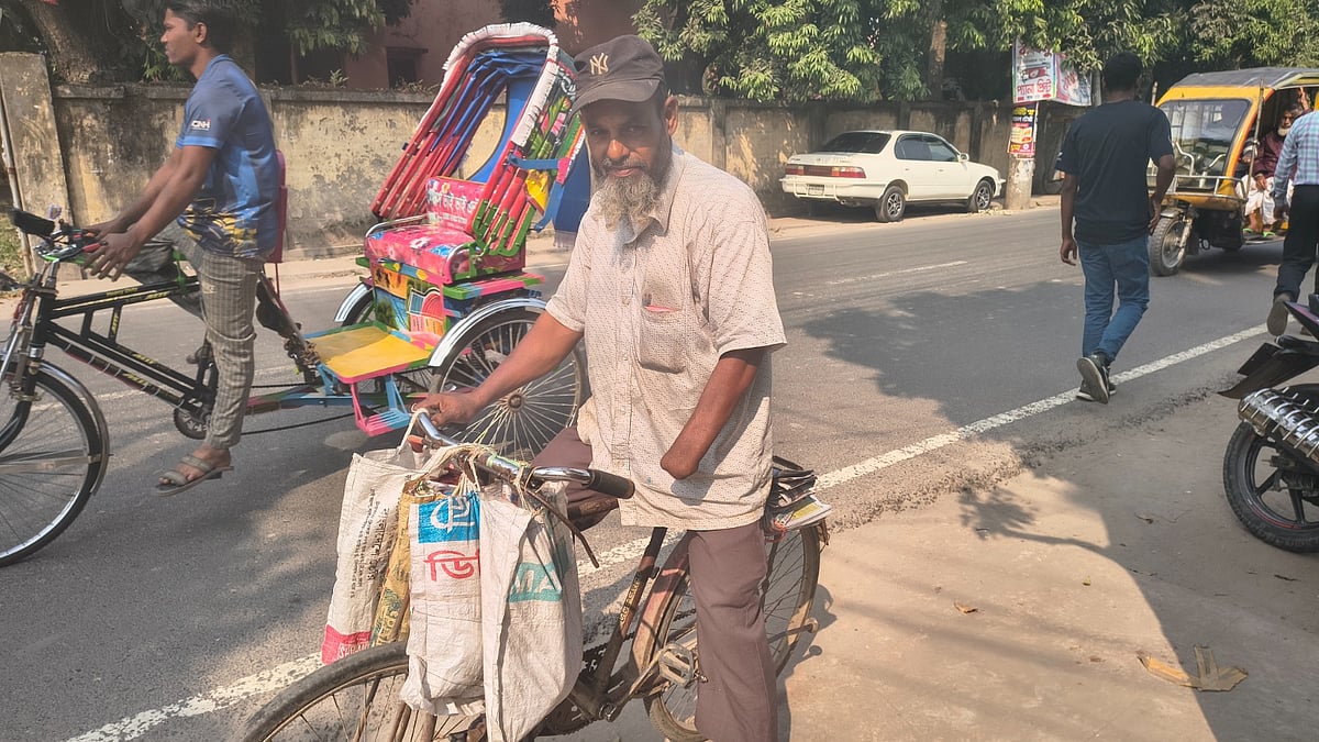 বাঁ হাতের কবজি না থাকলেও যশোরের আসাদুজ্জামান এক হাতে বাইসাইকেল চালিয়ে ঘরে ঘরে পত্রিকা পৌঁছে দেন। গতকাল বুধবার দুপুরে যশোর শহরের জেল সড়কের ঘোপ এলাকায়