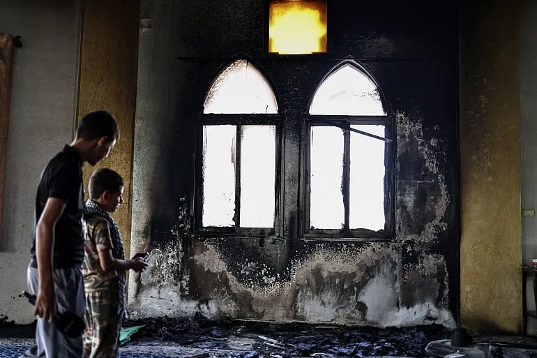 আগুনে পুড়ে যাওয়া মসজিদের ভেতর ঢুকে ক্ষয়ক্ষতি দেখছে দুই শিশু–কিশোর। ১৩ নভেম্বর ২০২৫