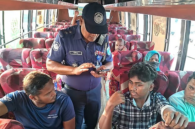 ঢাকার সাভারের আমিনবাজারে ঢাকা-আরিচা মহাসড়কের ঢাকামুখী লেনে বাসের এক যাত্রীর মুঠোফোনে তল্লাশি চালাচ্ছে পুলিশ। ১২ নভেম্বর বিকেলে