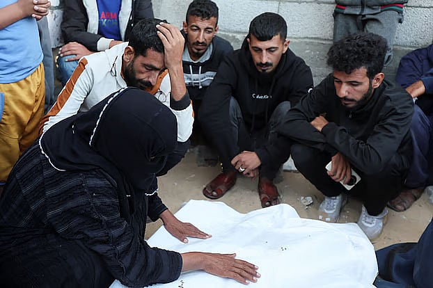 গাজায় ইসরায়েলের হামলায় নিহত এক ফিলিস্তিনির মরদেহের পাশে স্বজনদের আহাজারি। ১৯ অক্টোবর, ২০২৫, খান ইউনিস