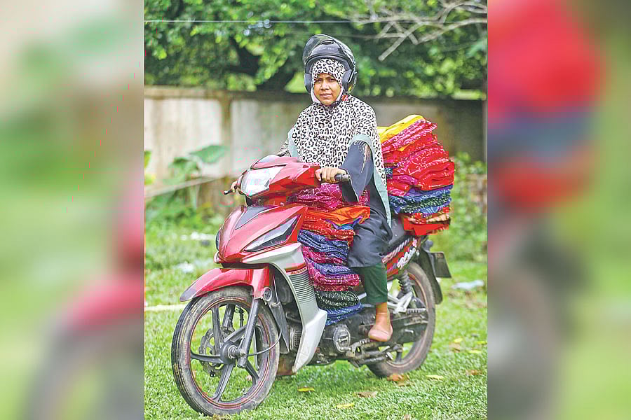 রুনা বেগম স্কুটি চালিয়ে সিলেট নগরের বিভিন্ন এলাকার দোকান ও বিপণিবিতানে নকশিকাঁথা
পৌঁছে দেন। সম্প্রতি তোলা ছবি