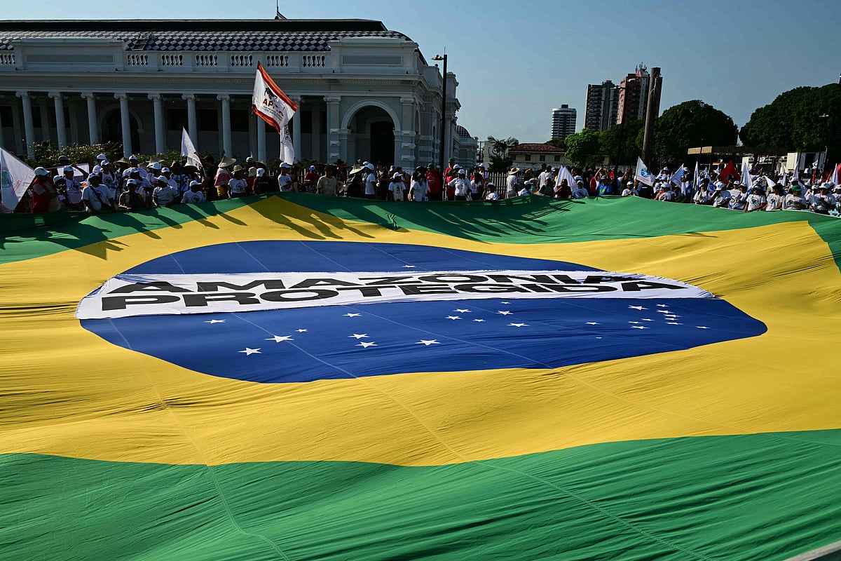 জাতিসংঘ জলবায়ু পরিবর্তন সম্মেলনের সাইডলাইনে গ্রেট পিপল’স মার্চে বিক্ষোভকারীরা একটি বিশাল ব্রাজিলিয়ান পতাকা মেলে ধরেন। শনিবার ব্রাজিলের প্যারা অঙ্গরাজ্যের বেলেম শহরে