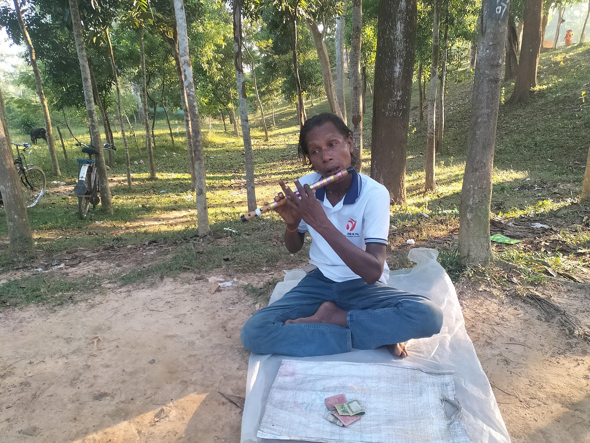 লেকের পাড়ে বসে এক মনে বাঁশি বাজান কৃষ্ণ দাস। সম্প্রতি মৌলভীবাজারের কমলগঞ্জের মাধবপুর লেক এলাকায়