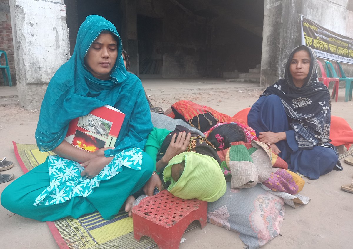 সাভারের আশুলিয়ার নিশ্চিন্তপুর এলাকায় তাজরীন ফ্যাশনস লিমিটেডের ফাঁকা ভবনের সামনে খোলা আকাশের নিচে শুয়ে আছেন কয়েকজন নারী শ্রমিক। আজ সোমবার সকাল ৭টার দিকে