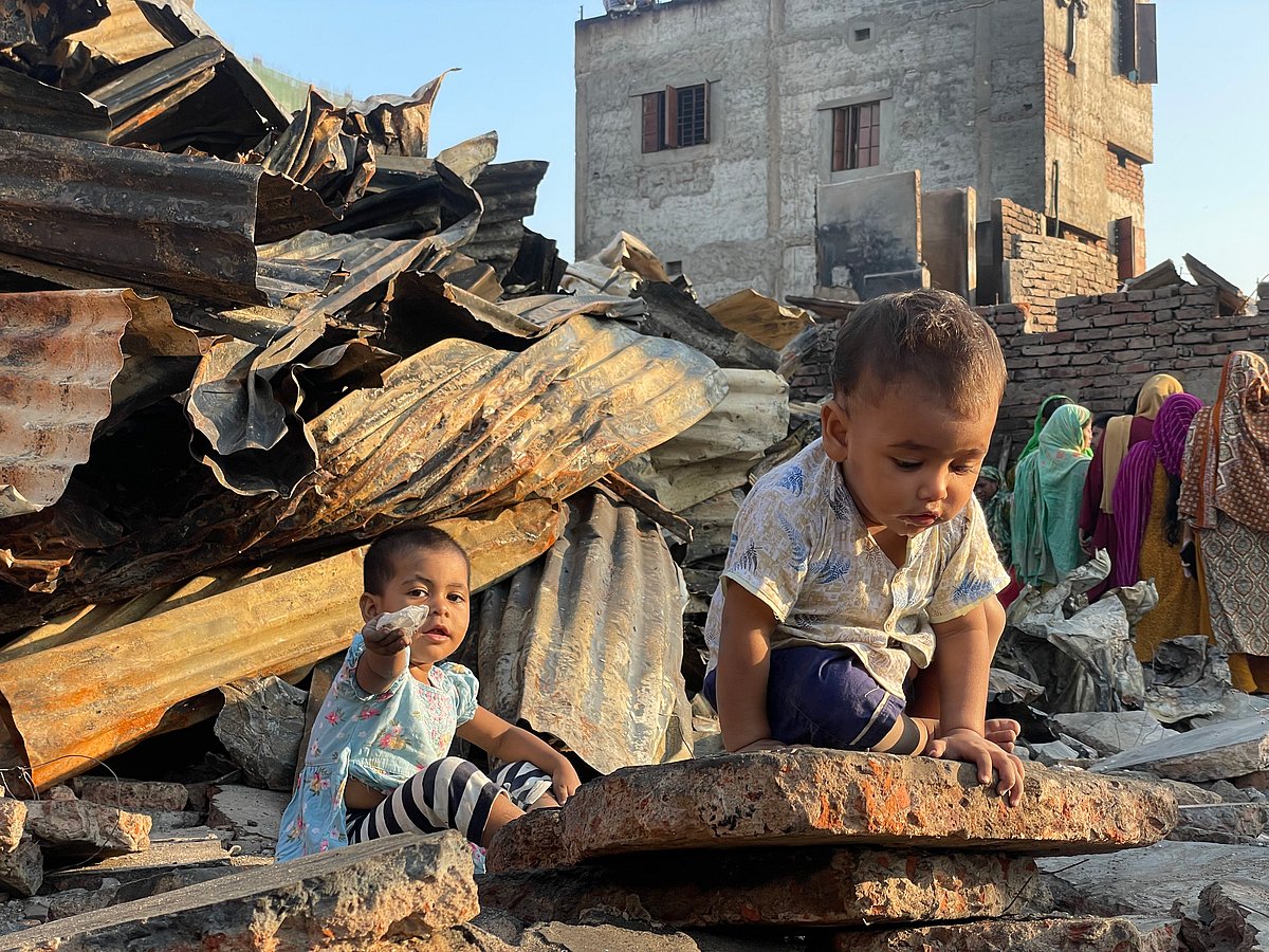 ‎নিজেদের পোড়া বাড়ির ধ্বংসস্তূপে খেলছে শিশু ফাতেমা (৩) ও জান্নাত (১)