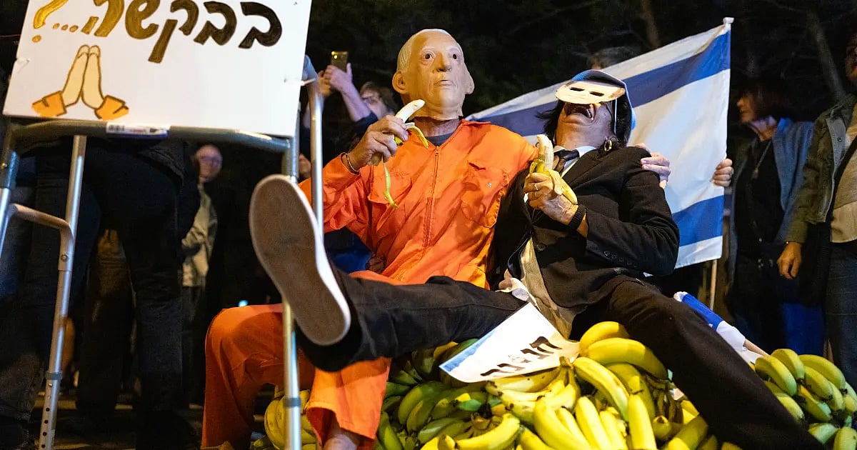 কারাবন্দীদের কমলা রঙের পোশাক পরে, বেনিয়ামিন নেতানিয়াহুর আদলে সেজে বিক্ষোভে অংশ নেন একজন। তেল আবিব, ইসরায়েল, ৩০ নভেম্বর ২০২৫