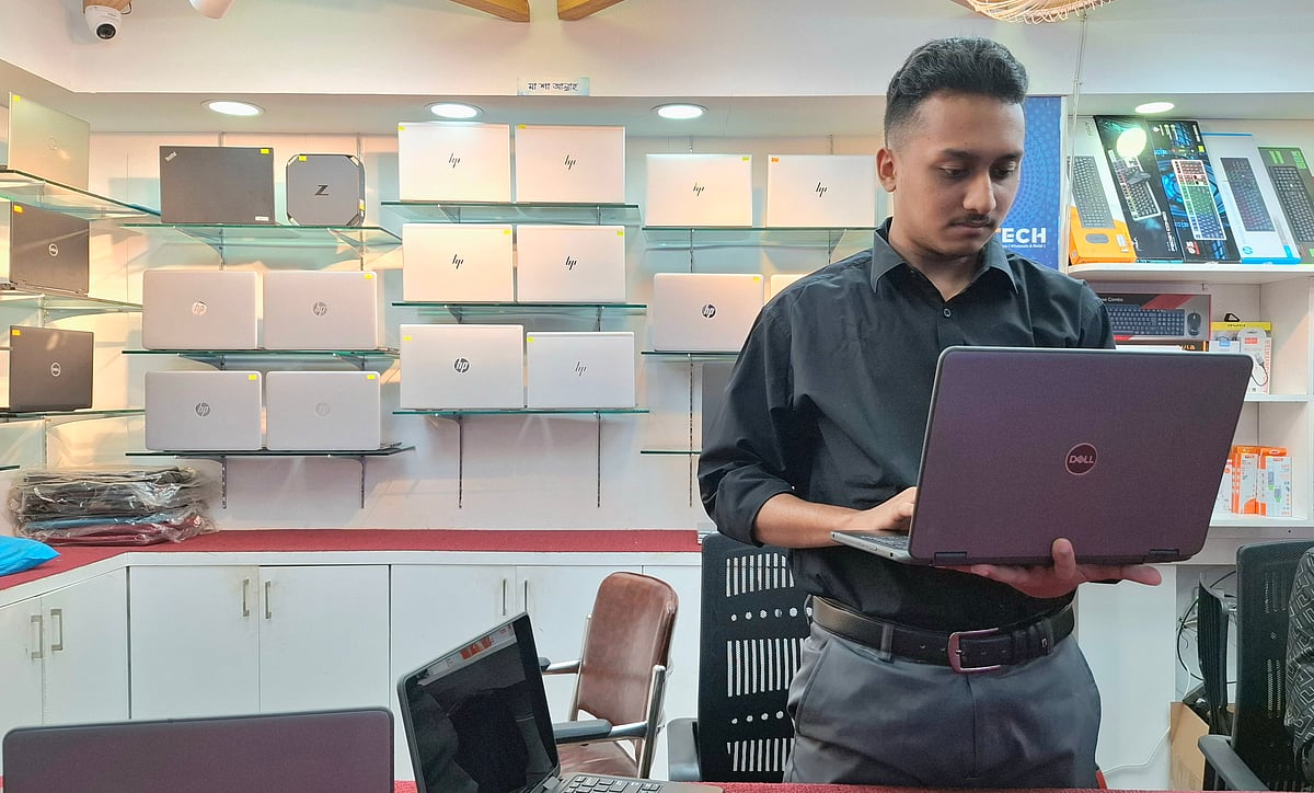 দোকানে পছন্দের ল্যাপটপ দেখছেন একজন ক্রেতা