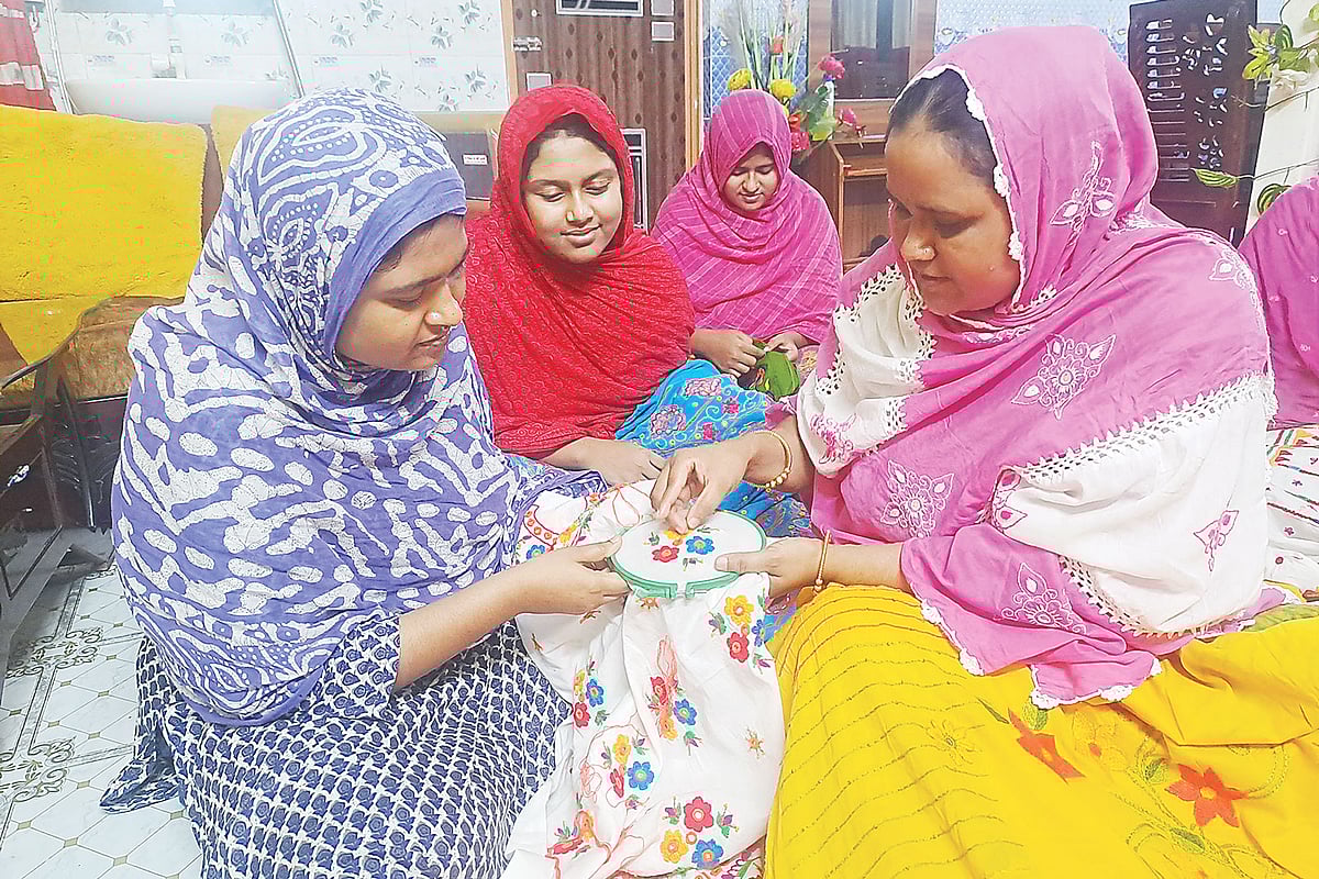 নিজের ঘরের মেঝেতে অন্য নারীদের কাজ শেখাচ্ছেন মিতু আক্তার। সম্প্রতি পলাশবাড়ীর নুনিয়াগাড়ি এলাকায়