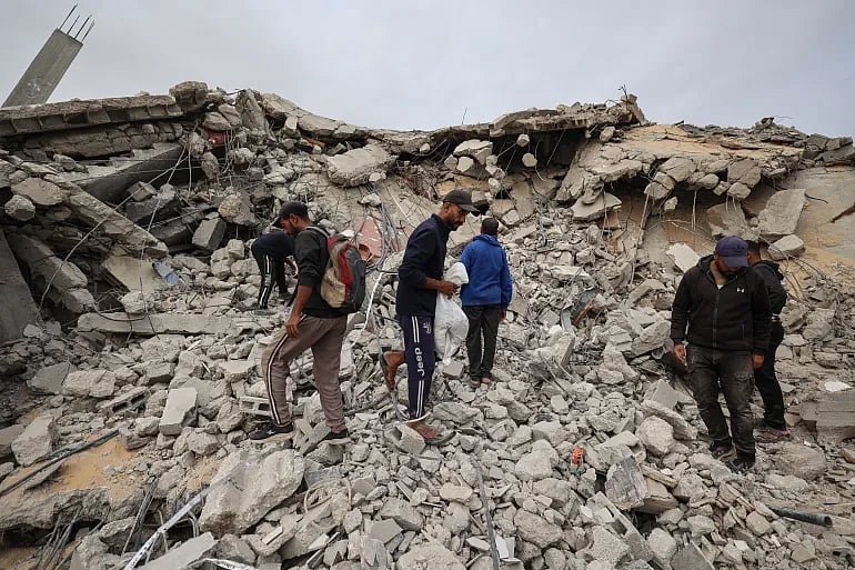 ফিলিস্তিনিরা মধ্য গাজার বুরেইজ শরণার্থীশিবিরে একটি ভবনের ধ্বংসাবশেষে নিহত ব্যক্তিদের দেহাবশেষ খুঁজছেন