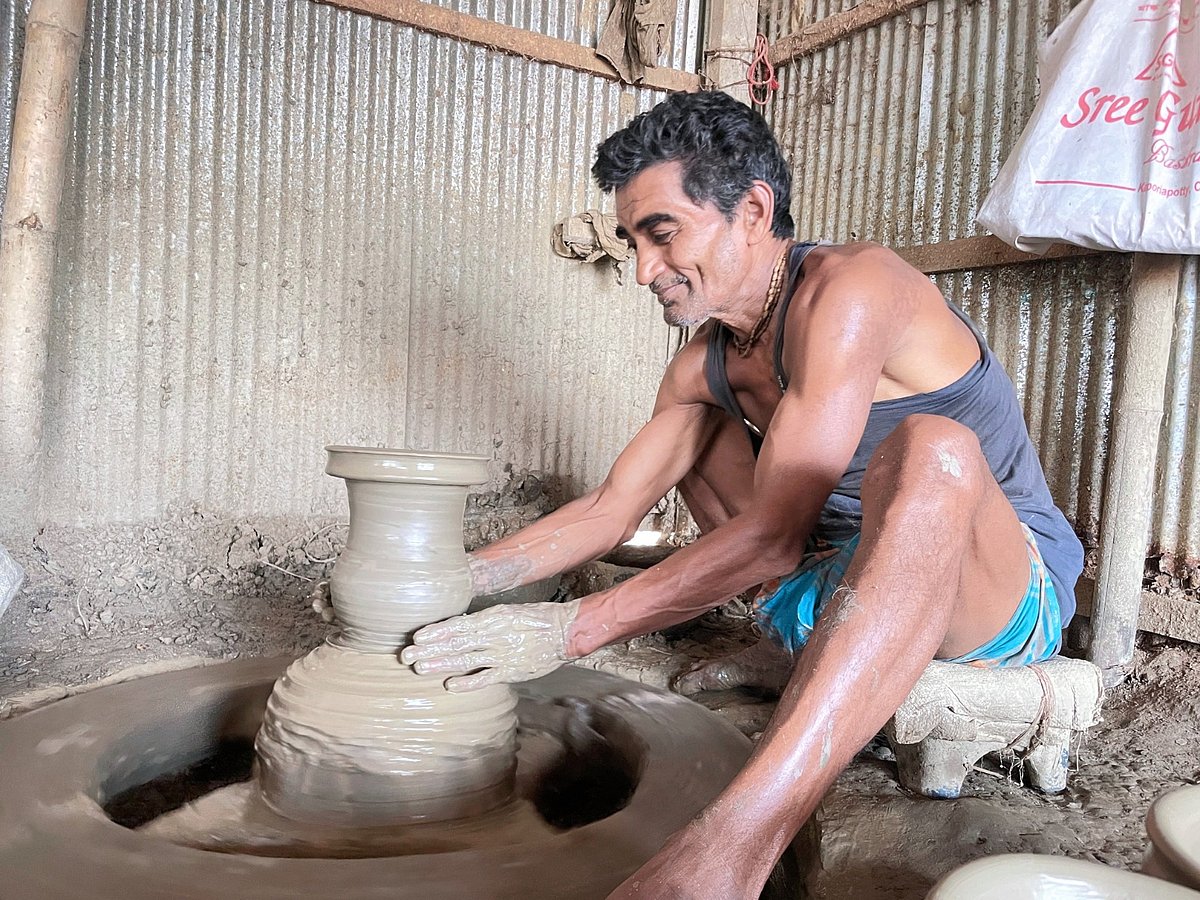 ক্যাপশন ১: কাঠের চাকা ঘুরিয়ে মাটির পণ্য তৈরিতে ব্যস্ত ষাটোর্ধ্ব মৃৎশিল্পী পরিমল পাল। সম্প্রতি কুমিল্লা সদর দক্ষিণ উপজেলার বিজয়পুর ইউনিয়নের বারপাড়া গ্রামে